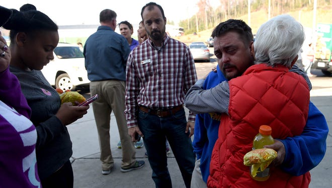 Michael Reed hugs a Red Cross volunteer as he continues to search for his missing wife and two daughters at the Rocky Top Sports World Red Cross shelter in Gatlinburg on Tuesday, Nov. 29, 2016. The family was separated during the wildfire evacuations.