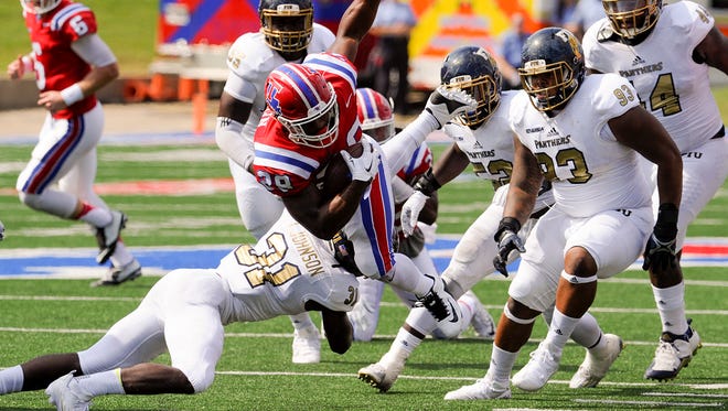 Louisiana Tech's Kenneth Dixon fights for extra yardage against FIU>