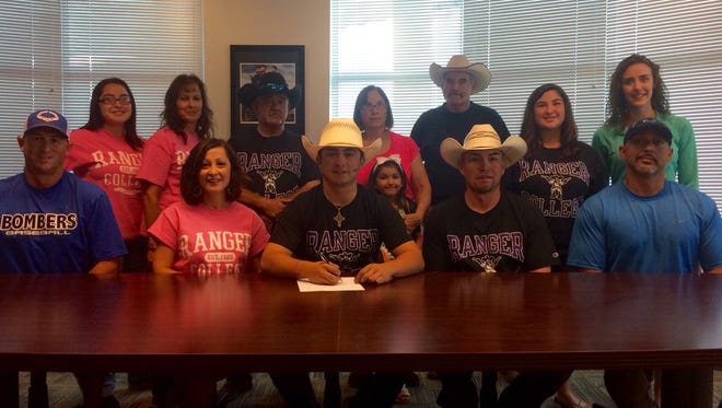 Bloomfield's Nick Felix III, bottom row at center, signs his national letter of intent on Thursday at Bloomfield High School surrounded by his family members, coaches and trainers. Felix will compete in rodeo at Ranger College in Ranger, Texas.