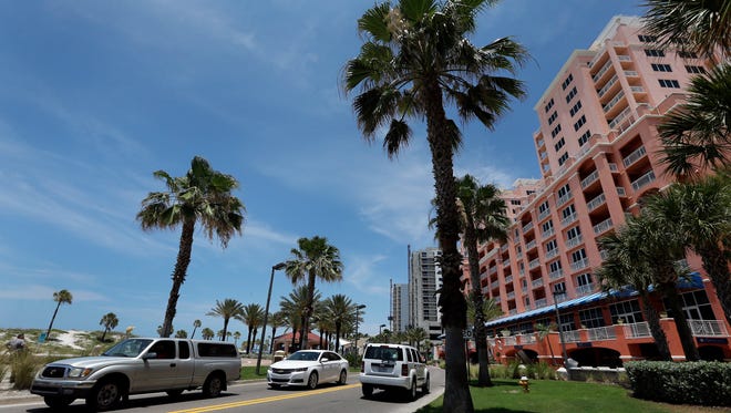 Traffic drives down South Gulfview Boulevard, a road that runs along the Gulf of Mexico, Thursday in Clearwater, Florida. More travelers are expected to take to the roads and sky this summer thanks to lower gas prices and an upbeat economy.