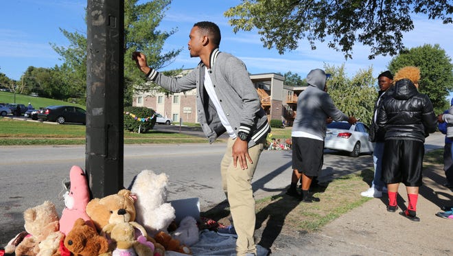 A man tends to a new teddy bear memorial on Tuesday, Sept. 23, 2014, in Ferguson, Mo., near the spot of where Michael Brown was shot by Ferguson police office Darren Wilson on Aug. 9.  The original teddy bear memorial was destroyed by fire earlier Tuesday morning. Ferguson police spokesman Devin James says the cause of the fire is under investigation. (AP Photo/St. Louis Post-Dispatch,  David Carson)  EDWARDSVILLE INTELLIGENCER OUT; THE ALTON TELEGRAPH OUT