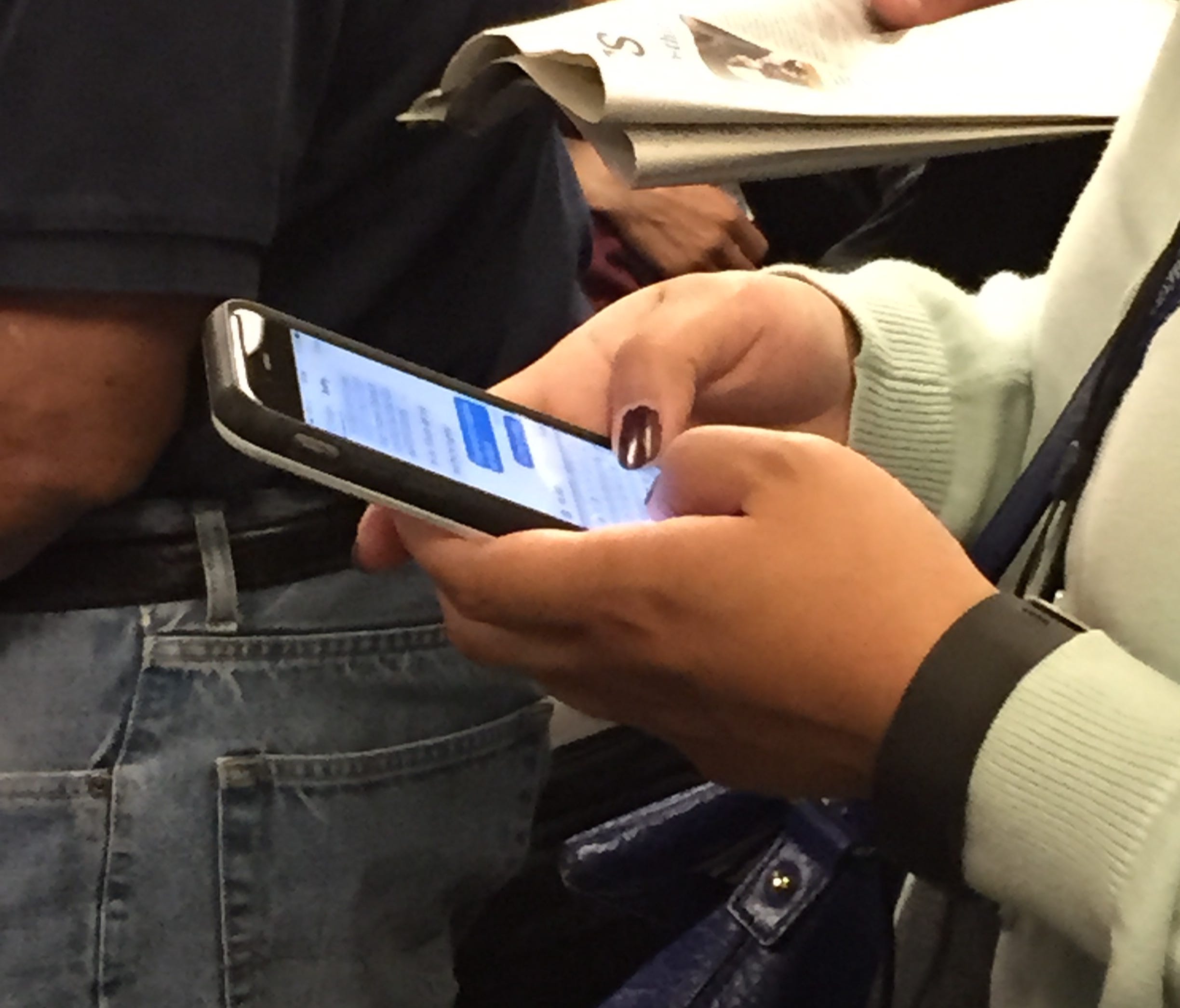 A rider texting on a BART train in San Francisco. With most office tools available on smart phones, it's often hard to unplug from work.