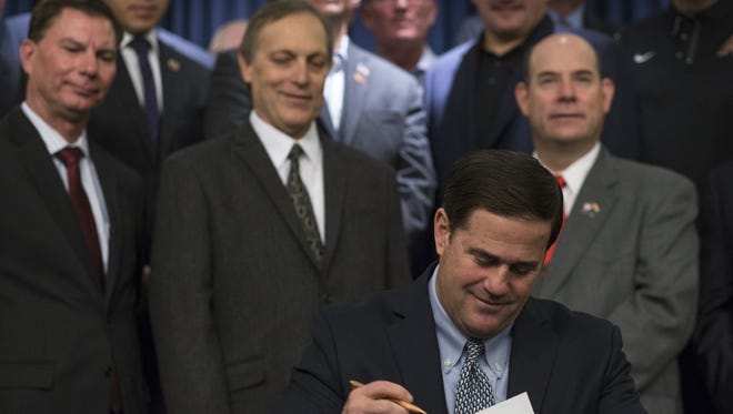 Gov. Doug Ducey signs the K-12 Education Funding Plan on Oct. 30, 2015, at the Arizona State Capitol.