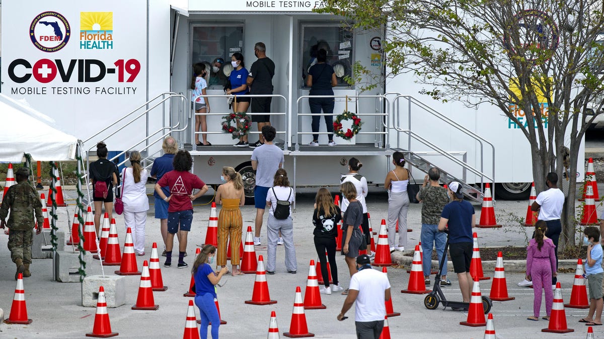 People wait in line to being tested at the COVID-19 mobile testing facility at Miami Beach Convention Center on Wednesday in Miami Beach, Fla.