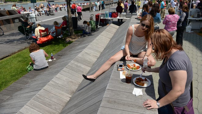 Nicki VanStraten, right, and Paige Peerenboom enjoy the food and ideal weather for this year’s first Dine on the Deck on the Fox River in Green Bay.