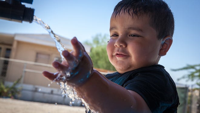 Axel Ruiz, 2, plays with arsenic-contaminated water at his family’s home in St. Anthony Mobile Home Park in California. (Maria Esquinca/News21)