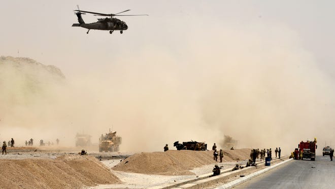 A U.S. black hawk helicopter flies over the site of a Taliban suicide attack in Kandahar on August 2, 2017.