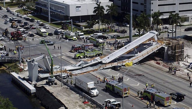 Emergency personnel respond after a brand-new pedestrian bridge collapsed onto a highway at Florida International University in Miami on March 15, 2018.