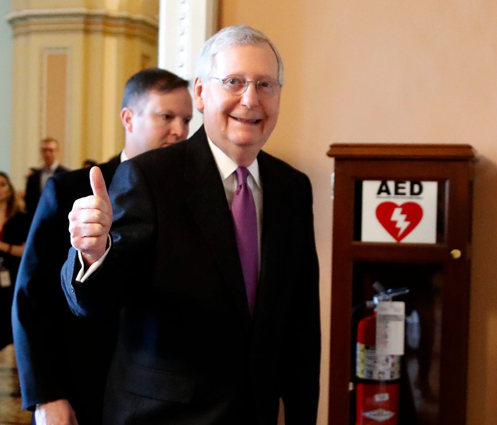 Senate Majority Leader Mitch McConnell of Ky., makes the thumbs up sign as he leaves the Senate floor after reaching an agreement to advance a bill ending the government shutdown, Jan. 22, 2018.