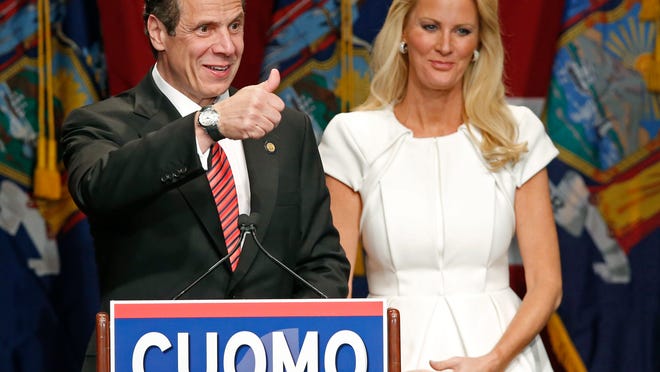 
Democratic New York Gov. Andrew Cuomo, left, gives a thumbs-up to the crowd as he celebrates with his partner, TV chef Sandra Lee, after defeating Republican challenger Rob Astorino.
