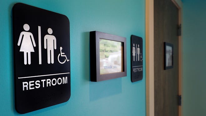 Who's in the bathroom has become a hot-button issue across America. Unisex signs hang outside bathrooms at a Durham, N.C. business. Debate over transgender bathroom access spreads nationwide as the U.S. Department of Justice countersues North Carolina Governor Pat McCrory from enforcing the provisions of House Bill 2 that dictate what bathrooms transgender individuals can use.