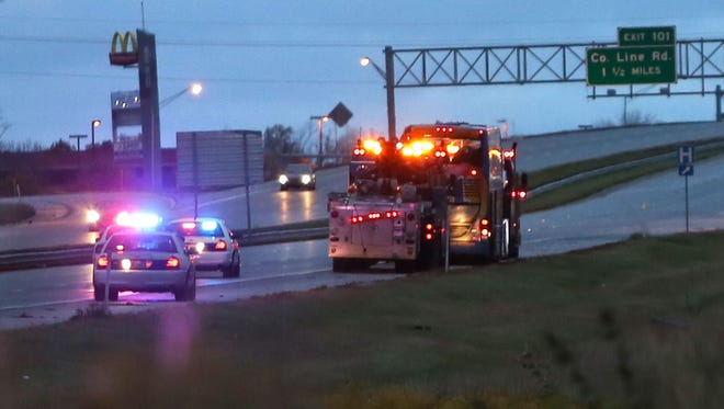 A double-decker bus is towed north on I-65 in Greenwood, Ind., after it overturned in an accident that sent several people to local hospitals Tuesday, October 14, 2014.