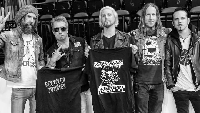 Shelter Slam founder John Delola, second from left, meets with Rob Zombie, left, and his bandmates John 5, Piggy D and Ginger Fish to get prizes and auction items for the fundraiser.