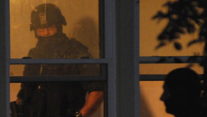 An officer takes part in a 2011 METRICH drug raid in Shelby.