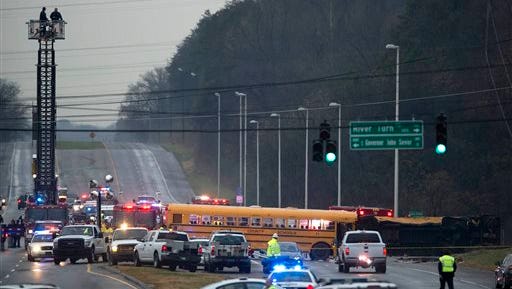 Emergency personnel close off the scene where two school buses serving Chilhowee Intermediate School and Sunnyview Primary School crashed in Knoxville, Tenn., Tuesday, Dec. 2, 2014.  At least three people died in the accident.  Two buses carrying children home from school collided on a Tennessee highway killing two students and an adult and injuring another 23 people.  Knoxville Police Chief David Rausch said the children who died were between the ages of kindergarten and third grade. The adult who died was an aide.   (AP Photo/Knoxville News Sentinel, Paul Efird)