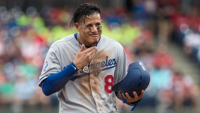 Los Angeles Dodgers shortstop Manny Machado (8) wipes dirt off his chin after sliding into third base against the Philadelphia Phillies during the first inning at Citizens Bank Park.