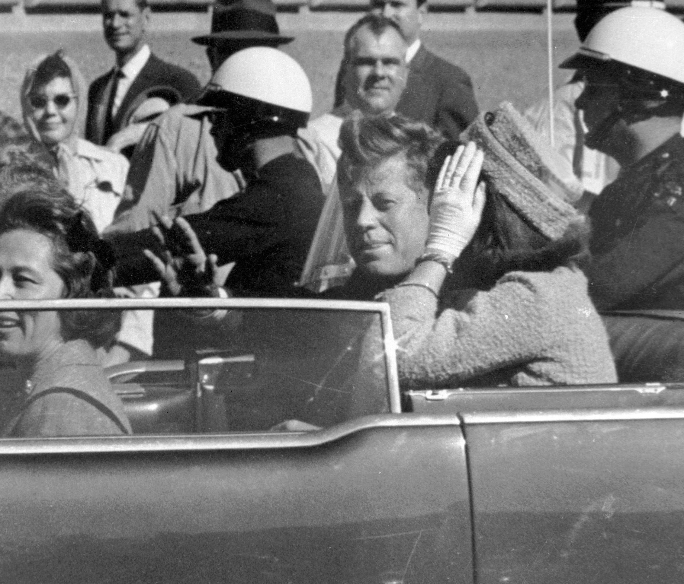 In this Nov. 22, 1963 file photo, President John F. Kennedy waves from his car in a motorcade in Dallas.