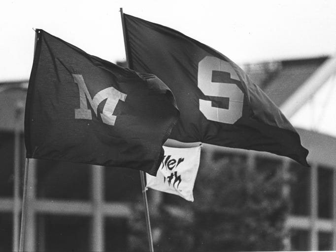 The University of Michigan and Michigan State flags