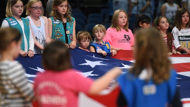 Area Girl Scouts hold the American flag for the singing of the National Anthem at a basketball game in 2015. The area council of the Girl Scouts is among the local nonprofits in the running for grants from A Community Thrives.