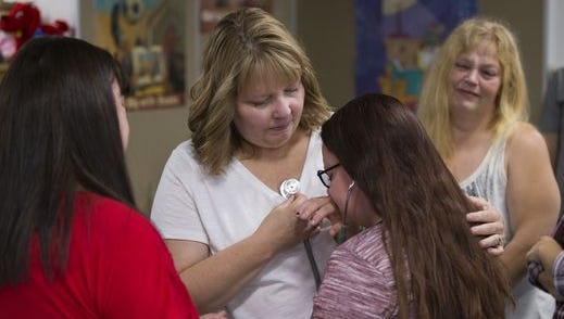 Lucy Boenitz (middle), lets Kelsey Pearson, 12, listen to her father's heart, transplanted in the body of Boenitz, during a meeting of Boenitz, Indianapolis, and the family of donor Matthew Boylen, Indianapolis, Saturday, Sept. 16, 2017. This is their first meeting, and came after a few years of correspondence by email and on social media.