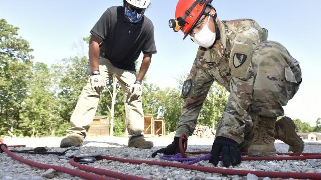 Staff Sgt. Harry Cruz, a Construction Engineer Supervisor at Fort Hood, Texas, demonstrates the building of a 9:1 compound mechanical advantage system while Kito Perry, an Urban Search and Rescue course training instructor, provides technical assistance.