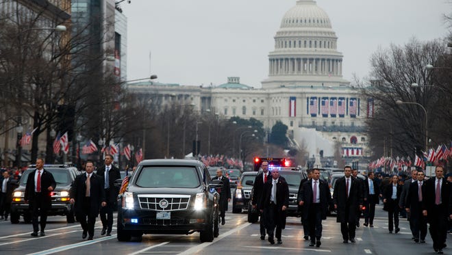 Secret Service agents escort President Donald Trump's vehicle.