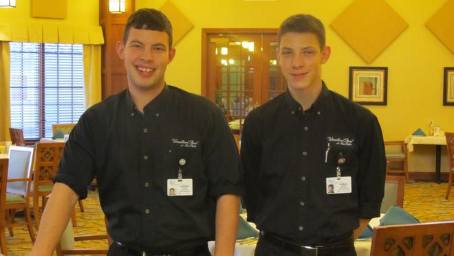 Jeffrey Seitz and Samuel Seitz, dining services team members of Woodland Pond, prepare to serve residents their evening meal in the dining room.