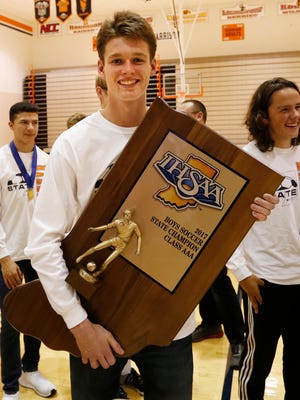 Goalkeeper Calvin Walters is all smiles as he carries the State Champion trophy as the Harrison State Champion boys soccer team is honored Thursday, November 2, 2017, in Harold R. May Gymnasium at Harrison High School.