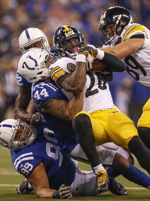 Pittsburgh Steelers running back Le'Veon Bell (26) is wrapped up after a short gain by the Indianapolis Colts defense at Lucas Oil Stadium in Indianapolis on Sunday, Nov. 12, 2017.
