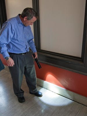 Director of Public Works David Biebel shines a flashlight on an area Thursday where an exterior wall is shown to be pulling away from the third floor of Sheboygan's City Hall.