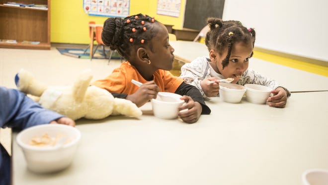Alameyah Lett, right, enjoys a two-bowl cereal morning at Carver because Alimazi Kennings, left, does not eat milk with her cereal. The preschoolers often start their day with something to eat before their active day starts.