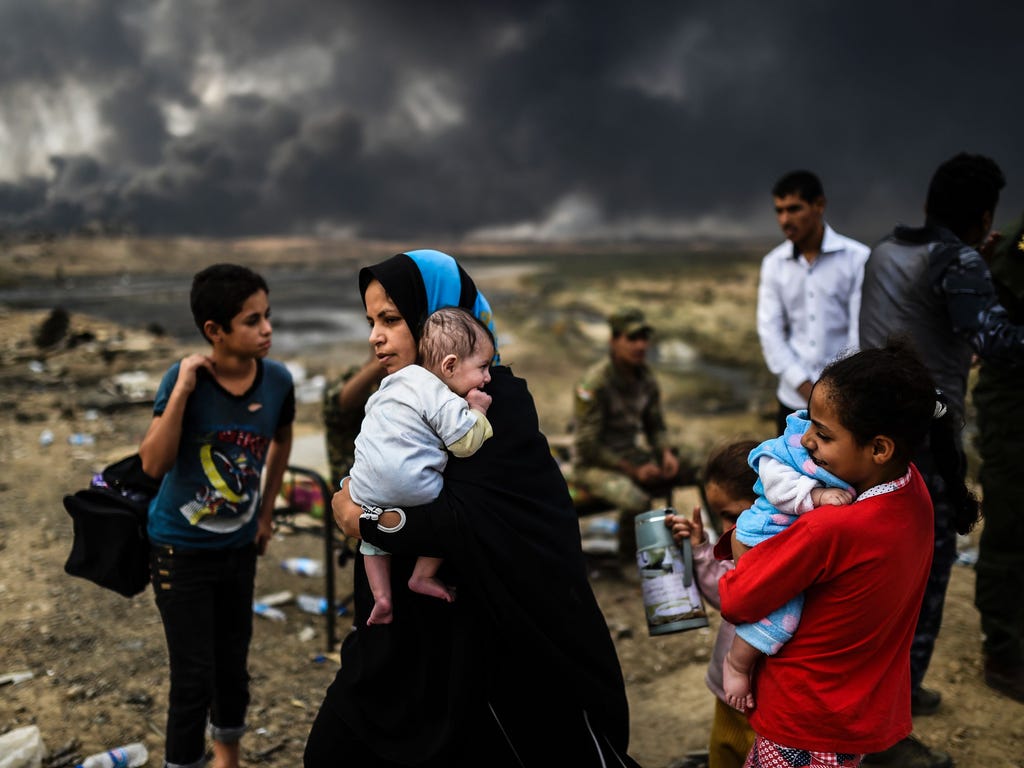 Iraqi families, who were displaced by the ongoing operation by Iraqi forces against jihadists of the Islamic State group to retake the city of Mosul, are seen gathering on an area near Qayyarah.