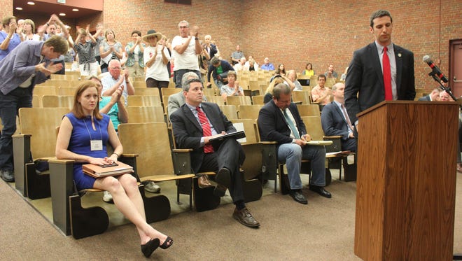 Members of the public applaud Cincinnati Councilman P.G. Sittenfeld, after he addresses representatives of the Ohio Power Siting Board about his concerns with Duke Energy's natural gas pipeline proposal Thursday at University of Cincinnati Blue Ash College.