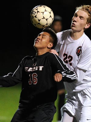 Green Bay East’s Manuel Villagrana heads a ball while defended by West De Pere’s Calvin Perry in the first half of Tuesday’s FRCC soccer game.