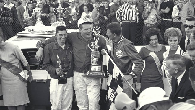 Driver Tiny Lund is flanked by team owners Glen Wood, left, and Leonard Wood in victory lane after winning the 1963 Daytona 500.