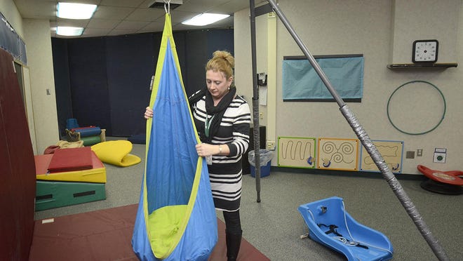 Principal Jeanine Kleber hangs the cocoon swing Jan. 11 in the sensory room at Haverhill Elementary School in Fort Wayne, Ind.