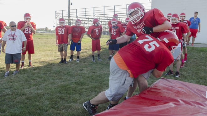 Marlette's Hunter Rye hits teammate Austin Ledsworth in a tackle drill Wednesday, Aug. 10 , 2016 during their football practice at Marlette High School.