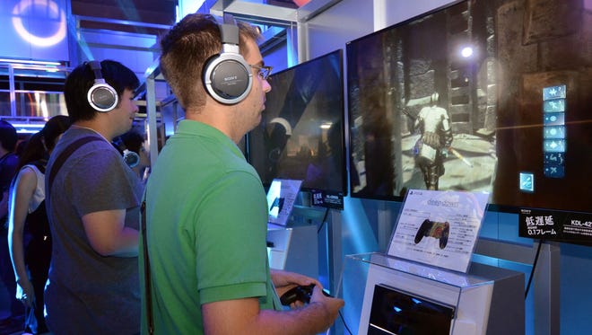 Visitors try out the PlayStation 4 at the Tokyo Game Show in Chiba, suburban Tokyo in September.