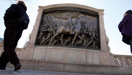 FILE - In this March 26, 2011, file photo people walk past the memorial to Union Col. Robert Gould Shaw and the 54th Massachusetts Volunteer Infantry Regiment, near the Statehouse in Boston. Boston police, who suspect vandalism, are investigating after it was reported Tuesday, Feb. 21, 2017 that a sword has broken off the memorial. The 54th was the first regiment composed of men of African decent recruited in the North for battle in the Civil War.