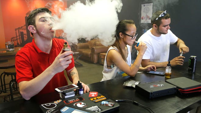 Brandon McKee, from left, Felicity Mason and Derek Hodge puff on their personal vape mods at The Fog Foundry Monday, April 18, 2016, at 2613 Maple Point Drive in Lafayette. Mason, 18, used to smoke, but enjoys the vape mods. "I do it for the flavor," she said. "Now I have no nicotine, it's healthier."