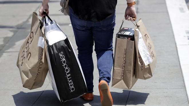In this July 3, 2018, file photo, a shopper carries bags in San Francisco.