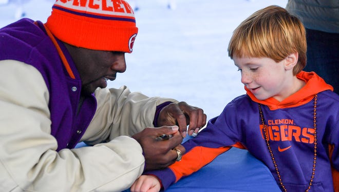 C.J. Spiller, right, signs an autograph to Landon Pierce of Clemson during the Sugar Bowl Fan Fest at the French Quarter in New Orleans on Sunday. 