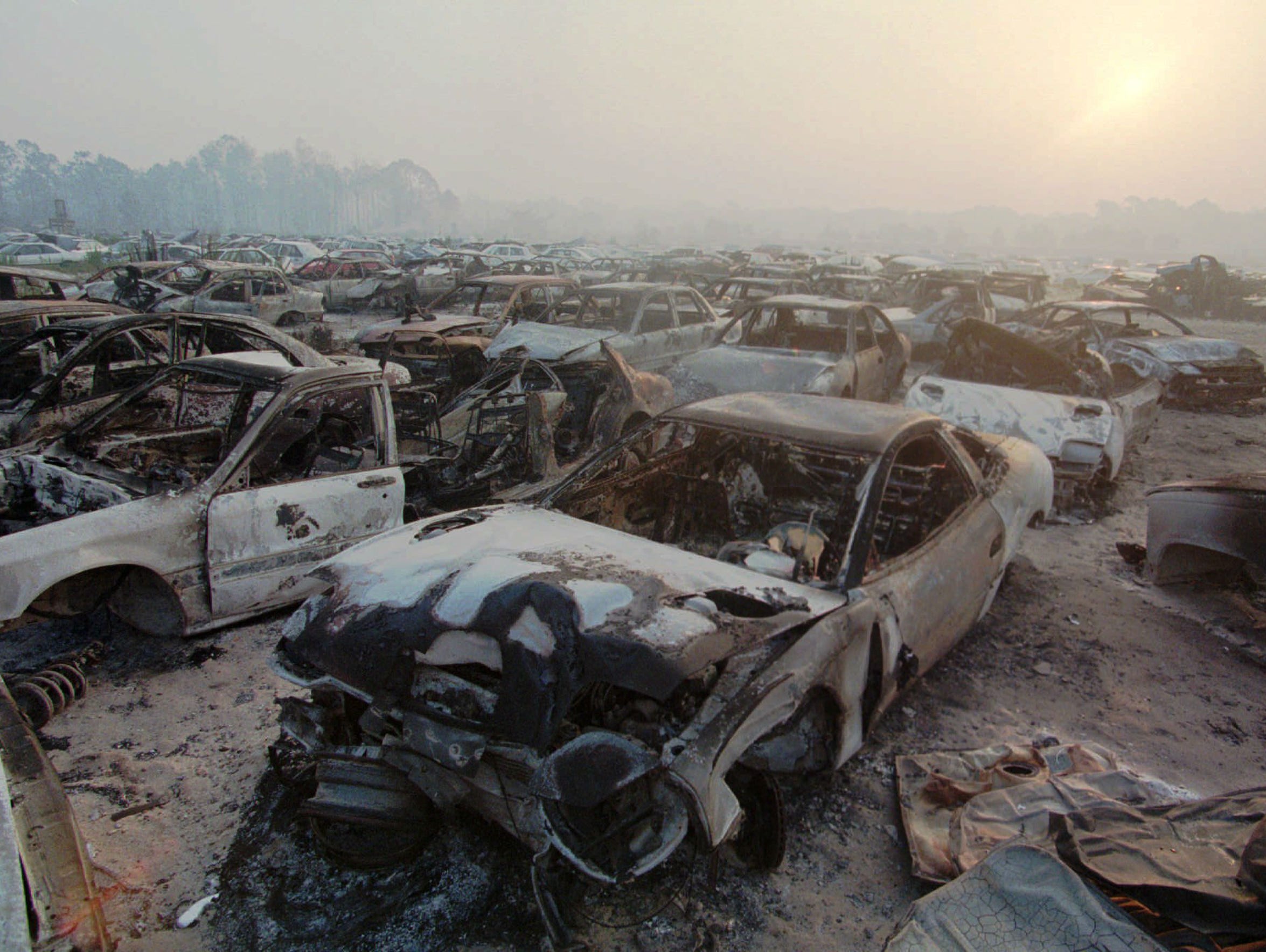 Burned cars litter an auto salvage company in Mims
