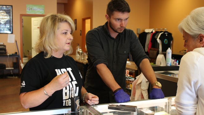 Stacey Hamliton, left, and Steven Everhart help Joyce Karper choose an electronic cigarette Tuesday, May 17, 2016, at Kaleidoscope Custom Vapor on South Church Street in Murfreesboro. Karper is using e-cigarettes to quit smoking conventional cigarettes.