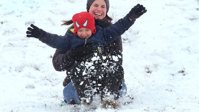 Cindy Canada and Quin Milam sled ride down a hill during the snow fall Sunday afternoon on the grounds of the Northview Church on Hazel Dell Parkway in Carmel. Cindy was babysitting Quin while his parents were in Phoenix working at the Super Bowl.