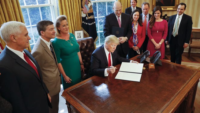 President Trump prepares to sign an executive order in the Oval Office on Feb. 3 that will direct the Treasury secretary to review the Dodd-Frank financial oversight law of 2010.