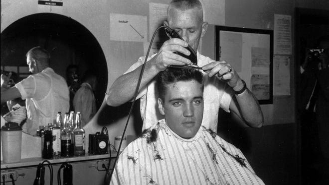Elvis Presley gets his first Army haircut at Fort Chaffee, Ark., from James B. Peterson.