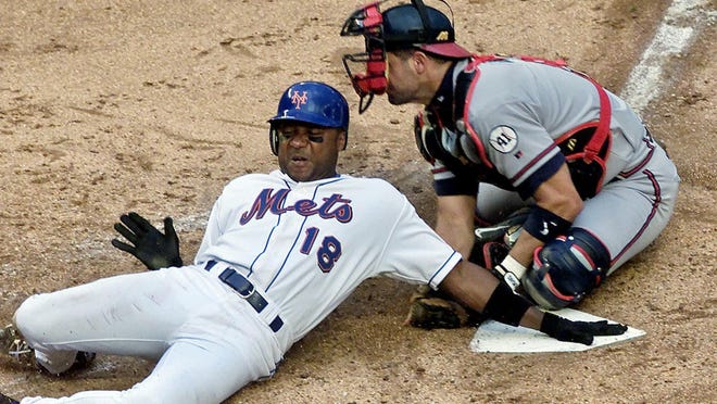 FILE - In this June 23, 2001, file photo, New York Mets' Darryl Hamilton is tagged out at home plate by Atlanta Braves catcher Javy Lopez during the third inning of a baseball game at Shea Stadium in New York. Authorities say Hamilton was killed Sunday, June 21, 2015, in a murder-suicide in the Houston suburb of Pearland, Texas. Pearland police say an initial investigation has determined Hamilton had been shot several times and that a woman in the home died of a self-inflicted gunshot wound. The woman was identified as Monica Jordan. (AP Photo/Lou Requena, File)