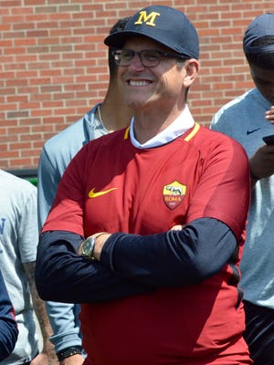 Michigan coach Jim Harbaugh, sporting an AS Roma shirt, watches as the U-M football team and AS Roma work out on Monday, July 17, 2017, in Ann Arbor.