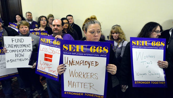 Furloughed Labor and Industry workers and allies, including  Laurie Haines, center, of York, stand outside Sen. Scott Wagner's office chanting "If we don't get no justice, you don't get no peace" following a rally to fund laid-off unemployment call center workers, Monday, Jan. 23, 2017. John A. Pavoncello photo